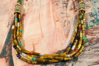 Genuine Tiger's Eye Necklace Featuring Genuine Turquoise, Spiny Oyster Shell, Coral and Black Onyx Accents. Sterling Silver and Gold Fill Barrels. Sterling Silver Beads & Clasp. Created by Navajo Artist Tommy Singer. Signed by the artist.